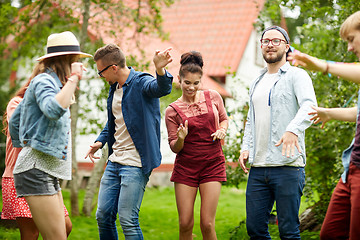 Image showing happy friends dancing at summer party in garden