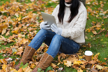 Image showing woman with tablet pc and coffee in autumn park