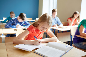 Image showing student girl with book writing school test