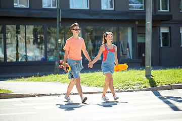 Image showing teenage couple with skateboards on city street