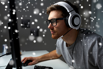 Image showing man in headset playing computer video game at home