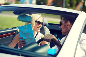 Image showing happy man and woman with map in cabriolet car