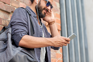 Image showing man with earphones, smartphone and bag on street