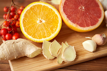 Image showing citrus, ginger, garlic and rowanberry on wood