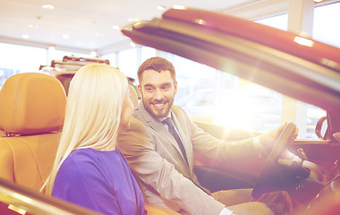 Image showing happy couple buying car in auto show or salon