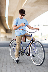 Image showing man with smartphone and earphones on bicycle