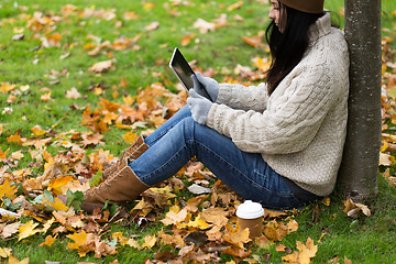 Image showing woman with tablet pc and coffee in autumn park