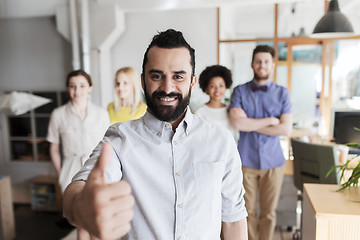 Image showing happy creative team showing thumbs up in office