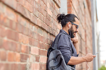 Image showing man with earphones, smartphone and bag on street