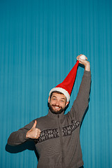 Image showing Smiling christmas man wearing a santa hat