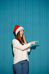 Image showing Surprised christmas girl wearing a santa hat