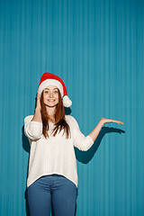 Image showing Surprised christmas girl wearing a santa hat