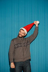 Image showing Smiling christmas man wearing a santa hat