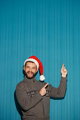 Image showing Smiling christmas man wearing a santa hat