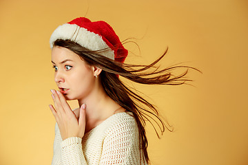 Image showing Surprised christmas girl wearing a santa hat