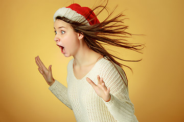 Image showing Surprised christmas girl wearing a santa hat