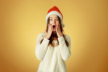 Image showing Surprised christmas girl wearing a santa hat