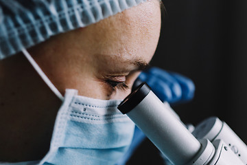 Image showing Female scientist looking at microscope