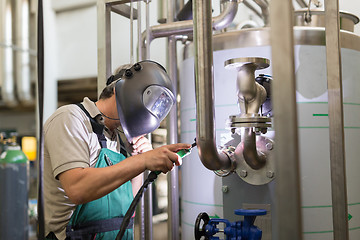 Image showing Industrial worker welding in metal factory.