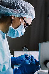 Image showing Female scientist arranging microscope glasses in box