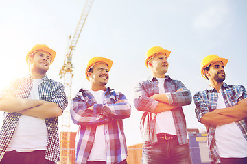 Image showing group of smiling builders in hardhats outdoors