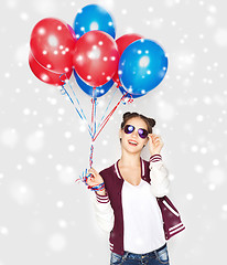 Image showing happy teenage girl with helium balloons over snow