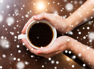 Image showing close up of woman holding hot black coffee cup