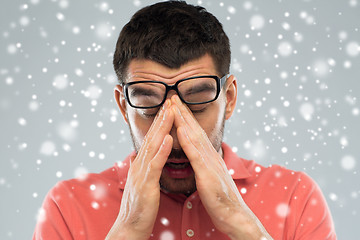 Image showing tired man with eyeglasses touching his nose bridge