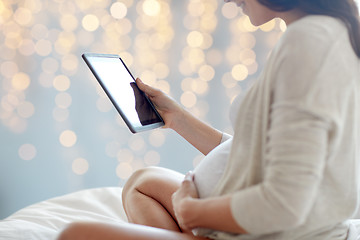 Image showing close up of pregnant woman with tablet pc in bed