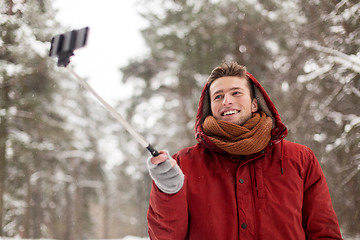 Image showing happy man taking selfie by smartphone in winter