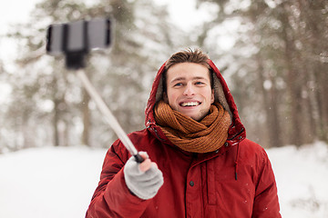 Image showing happy man taking selfie by smartphone in winter