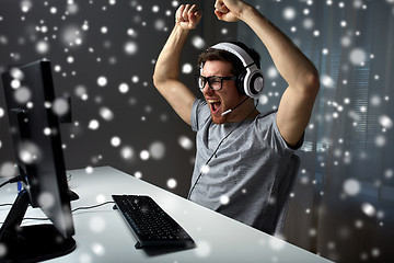 Image showing man in headset playing computer video game at home