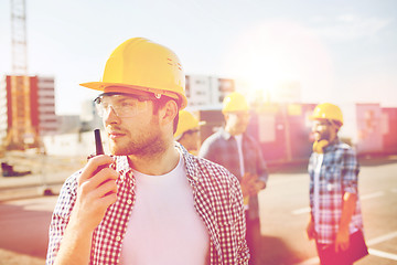 Image showing group of builders in hardhats with radio