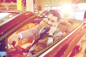 Image showing happy man sitting in car at auto show or salon