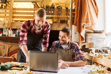 Image showing carpenters with laptop and blueprint at workshop