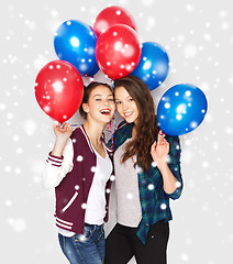 Image showing happy teenage girls with helium balloons over snow