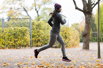 Image showing close up of young woman running in autumn park