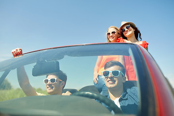 Image showing happy friends driving in cabriolet car