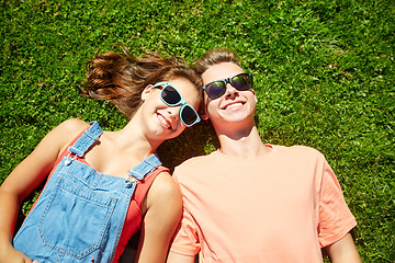 Image showing happy teenage couple lying on grass at summer