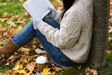 Image showing woman with book drinking coffee in autumn park