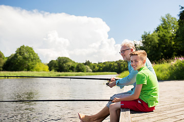 Image showing grandfather and grandson fishing on river berth