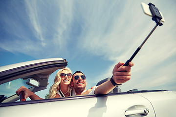 Image showing happy couple in car taking selfie with smartphone