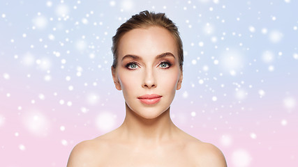 Image showing beautiful young woman face over snow