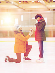 Image showing happy couple with engagement ring on skating rink