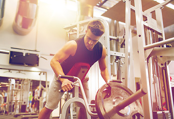 Image showing young man exercising on t-bar row machine in gym