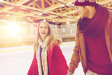Image showing happy couple holding hands on skating rink