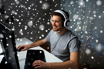 Image showing man in headset playing computer video game at home