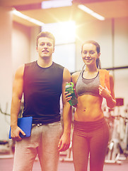 Image showing happy couple in gym with water and tablet pc