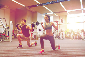 Image showing young man and woman training with barbell in gym