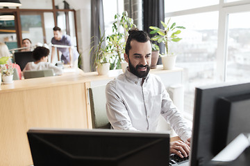 Image showing happy creative male office worker with computer